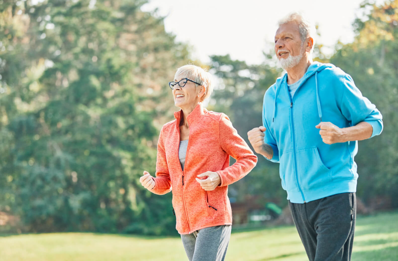 Two older adults on a jog through a local park to improve their cardio health.
